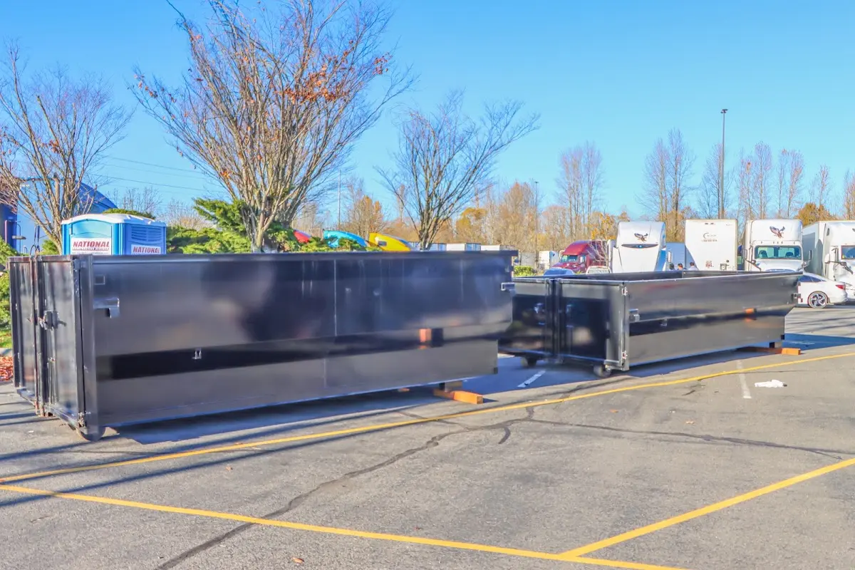 Professional dumpster rental service with roll-off container on residential driveway in West Samoset